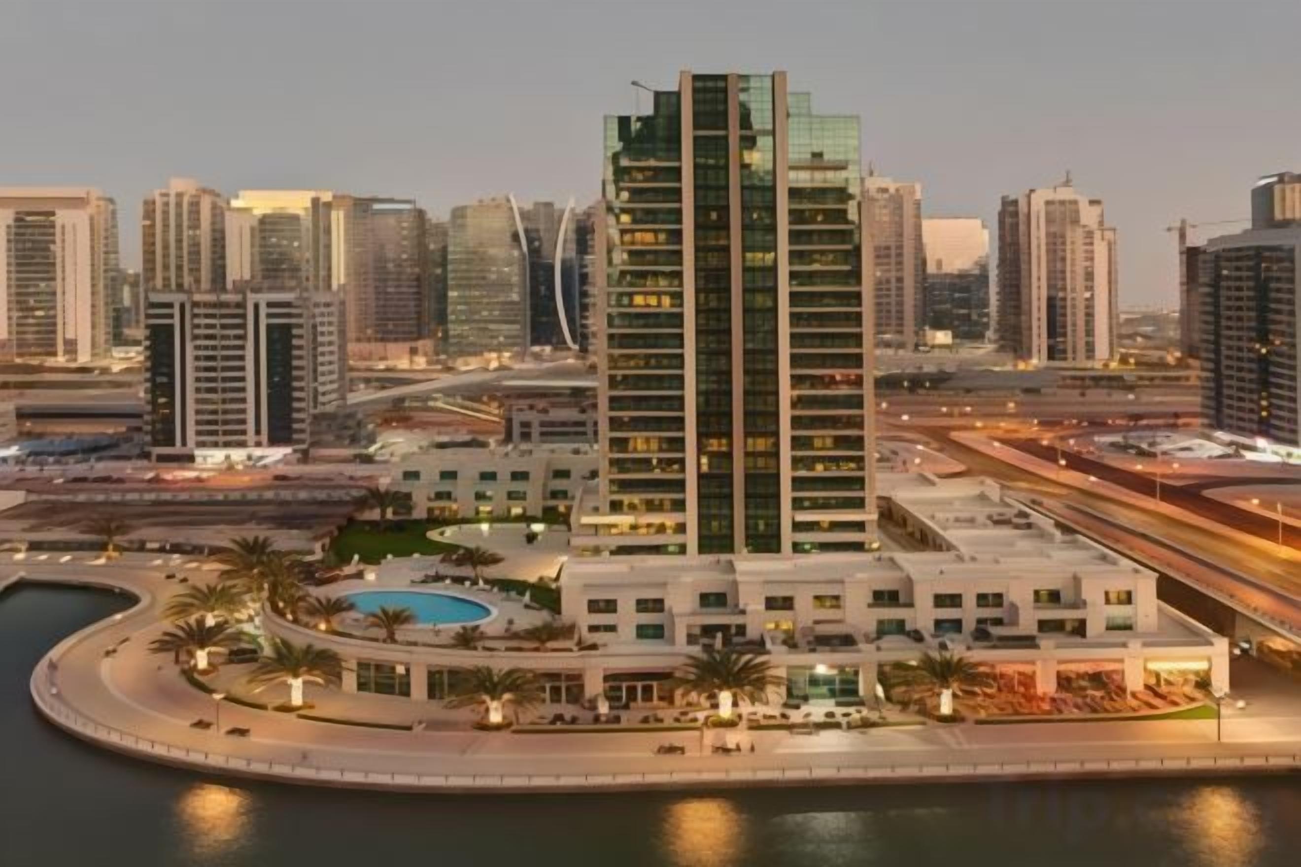 A high-rise building with a pool and a marina.