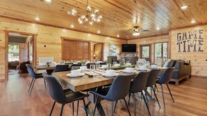 A wooden interior with a dining area, a television, and a 'GAME TIME' sign.