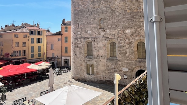 A courtyard with stone buildings, outdoor seating, and a staircase. - "LA PIOL" apartment in the heart of Hyères (Hyères)