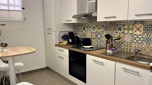 A kitchen with white cabinets, a coffee maker, a toaster, and a sink. - "LA PIOL" apartment in the heart of Hyères (Hyères)