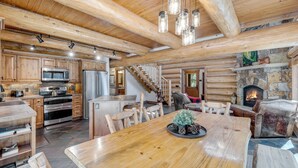 Une cuisine spacieuse avec des meubles en bois, un îlot central et une cheminée en pierre.