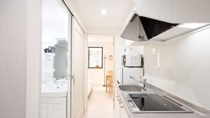 A modern kitchen with a built-in oven, microwave, and sink. - Calm Riverside Inn/Close to Ikebukuro (Tokyo)