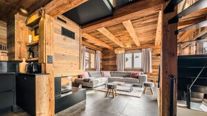 Ein modernes Blockhaus-Interieur mit Küche, Wohnbereich und Treppe.