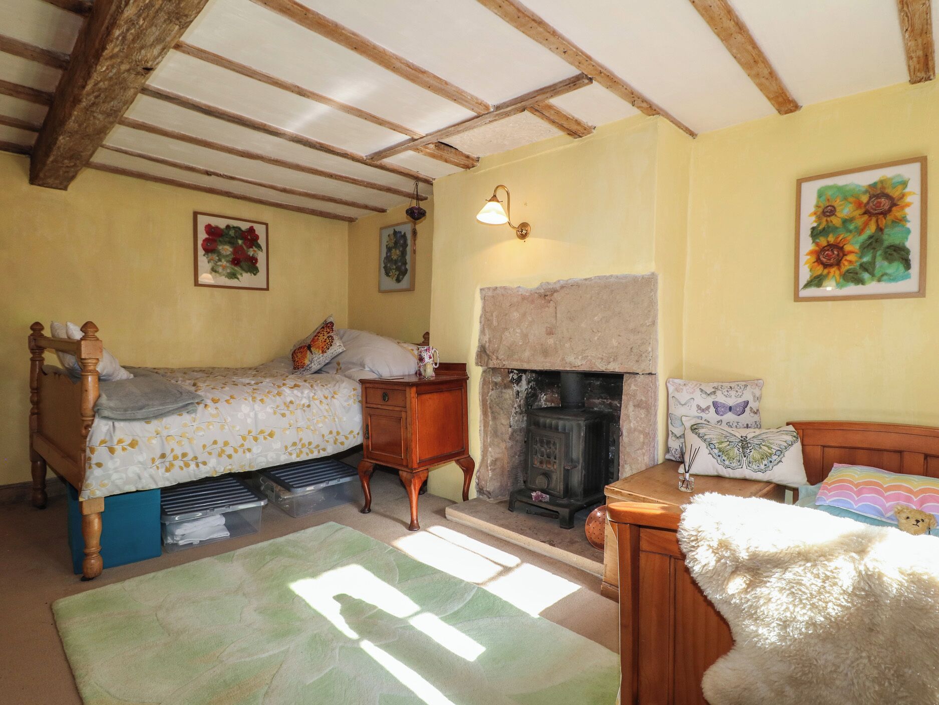 Une chambre confortable avec un lit, une table de chevet, une cheminée et une fenêtre laissant entrer la lumière naturelle.