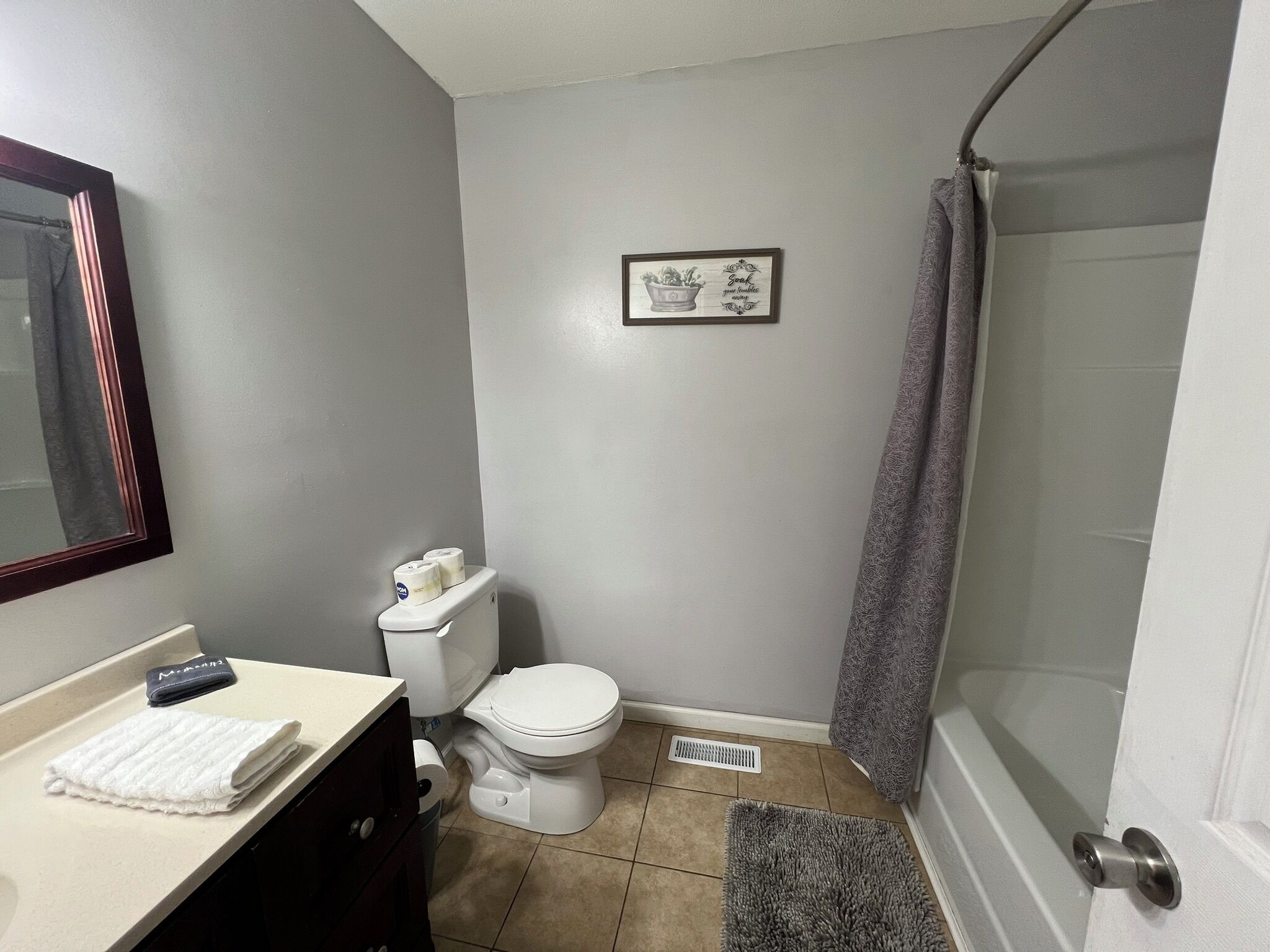 Une salle de bain avec des toilettes, un lavabo et une douche.