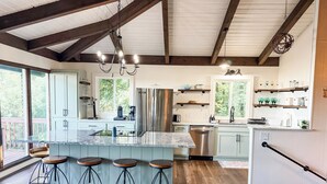 A spacious kitchen with a large island, bar stools, a stainless steel refrigerator, and wooden beams on the ceiling. - Archer's Perch -Incredible view - Right along the Blue Ridge Parkway (Hillsville)