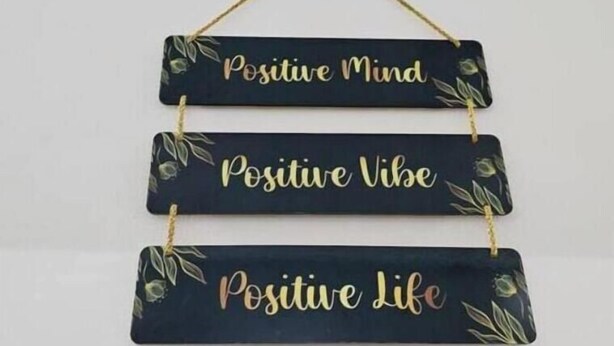 A wall-mounted decoration with three rectangular signs, each bearing a different phrase: "Positive Mind," "Positive Vibe," and "Positive Life." - Blumint 307 Yelahanka & Blumint 308 (Bengaluru)
