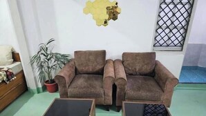 Ein Wohnzimmer mit zwei braunen Sofas und zwei Holztischen.