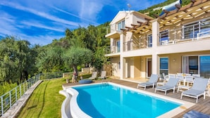 A two-story house with a swimming pool, outdoor seating, and a view of the surrounding greenery. - Villa Penelope With 4 Bedrooms and 3 Bathrooms (Corfu)