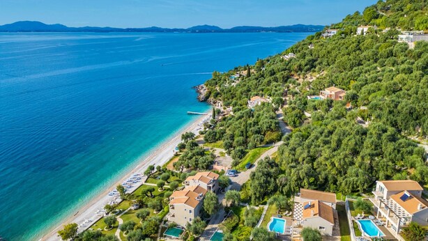 An aerial view of a coastal property with multiple buildings, a beach, and a clear blue sea. - Villa Penelope With 4 Bedrooms and 3 Bathrooms (Corfu)