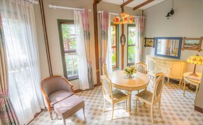 A room with a round table, two chairs, a cabinet, and a mirror. - Ban Mai Vintage (Pak Chong)