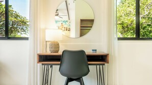 A modern room with a desk, chair, and a round mirror on the wall. - Casa Amor, 1-bedroom Villa with salt water pool, garden & mountain views (Ojochal)