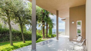 A covered outdoor area with a view of the landscape, featuring a seating area with chairs and a door. - The Vista Retreat N.1 (Treiso)