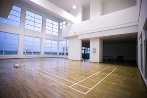 An indoor sports hall with a wooden floor, large windows, and a view of the sea. - Twin Galaxy Residence By The one - Johor Bahru (Johor Bahru)