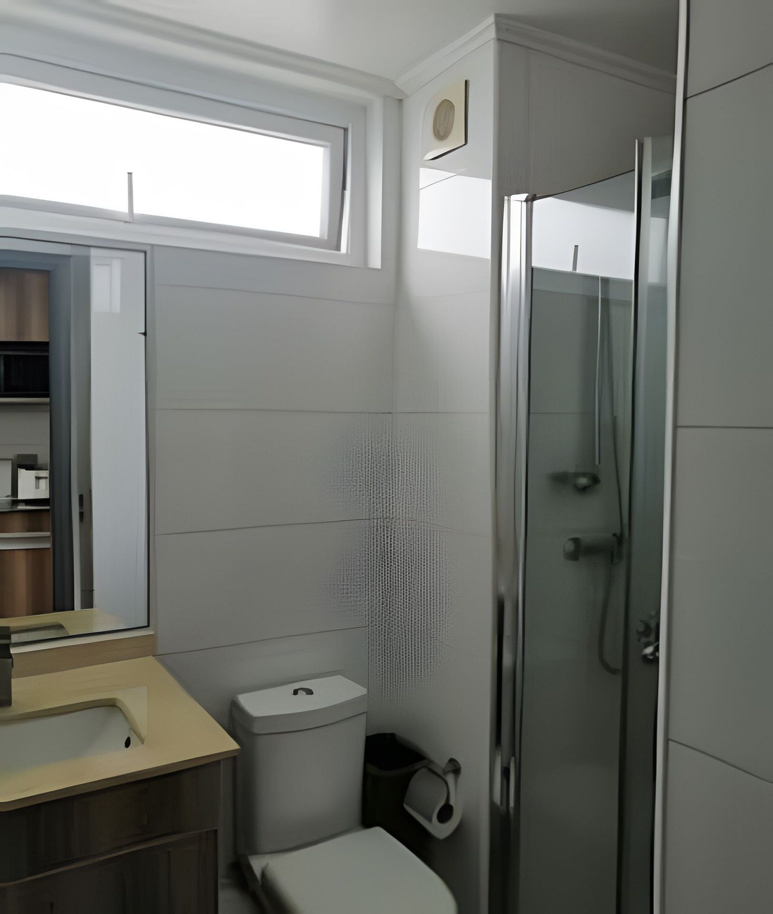 A modern bathroom with a toilet, sink, and shower.