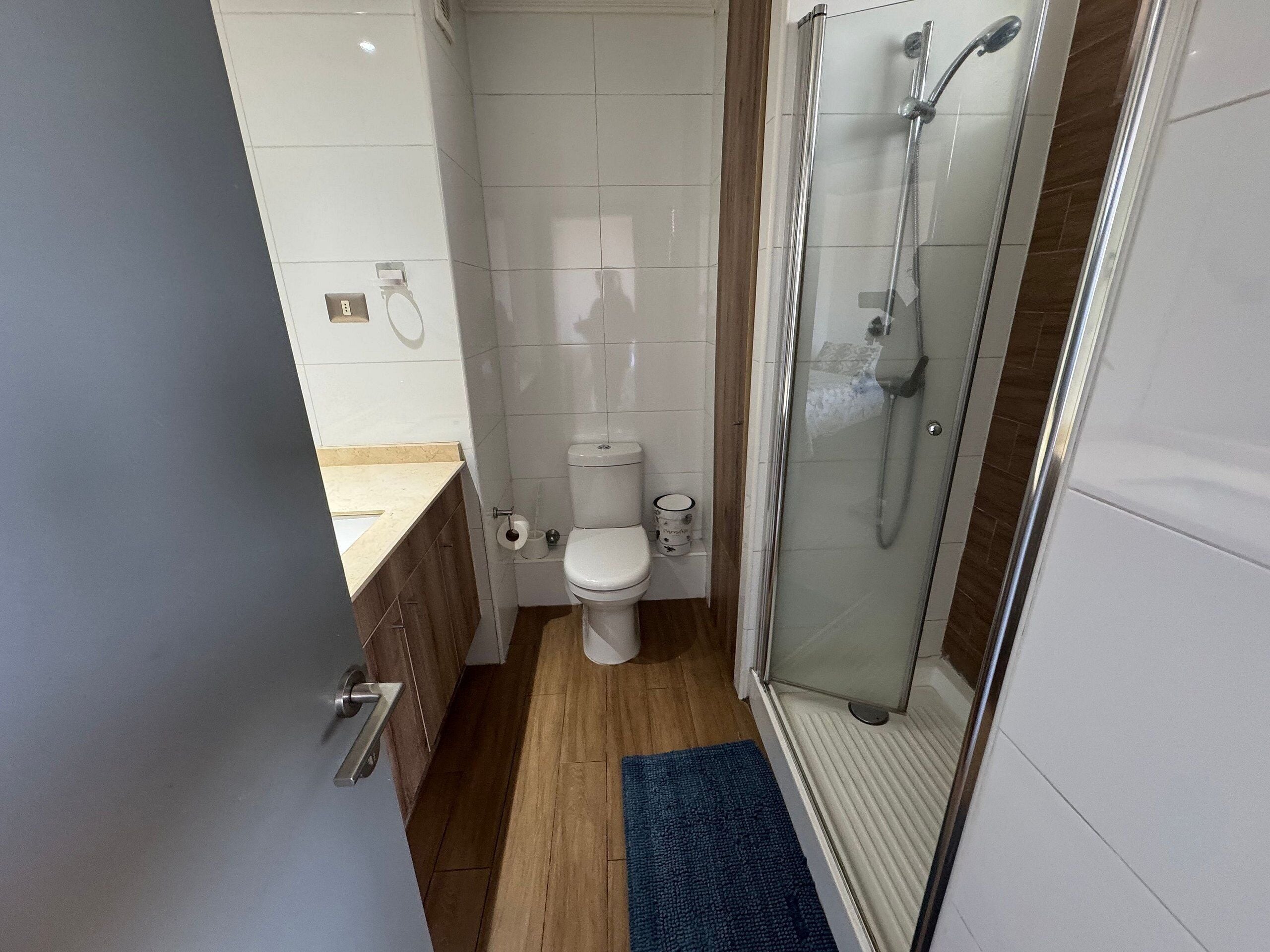 Un baño con inodoro, ducha y lavamanos.