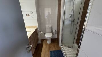 Un baño con inodoro, ducha y lavamanos.