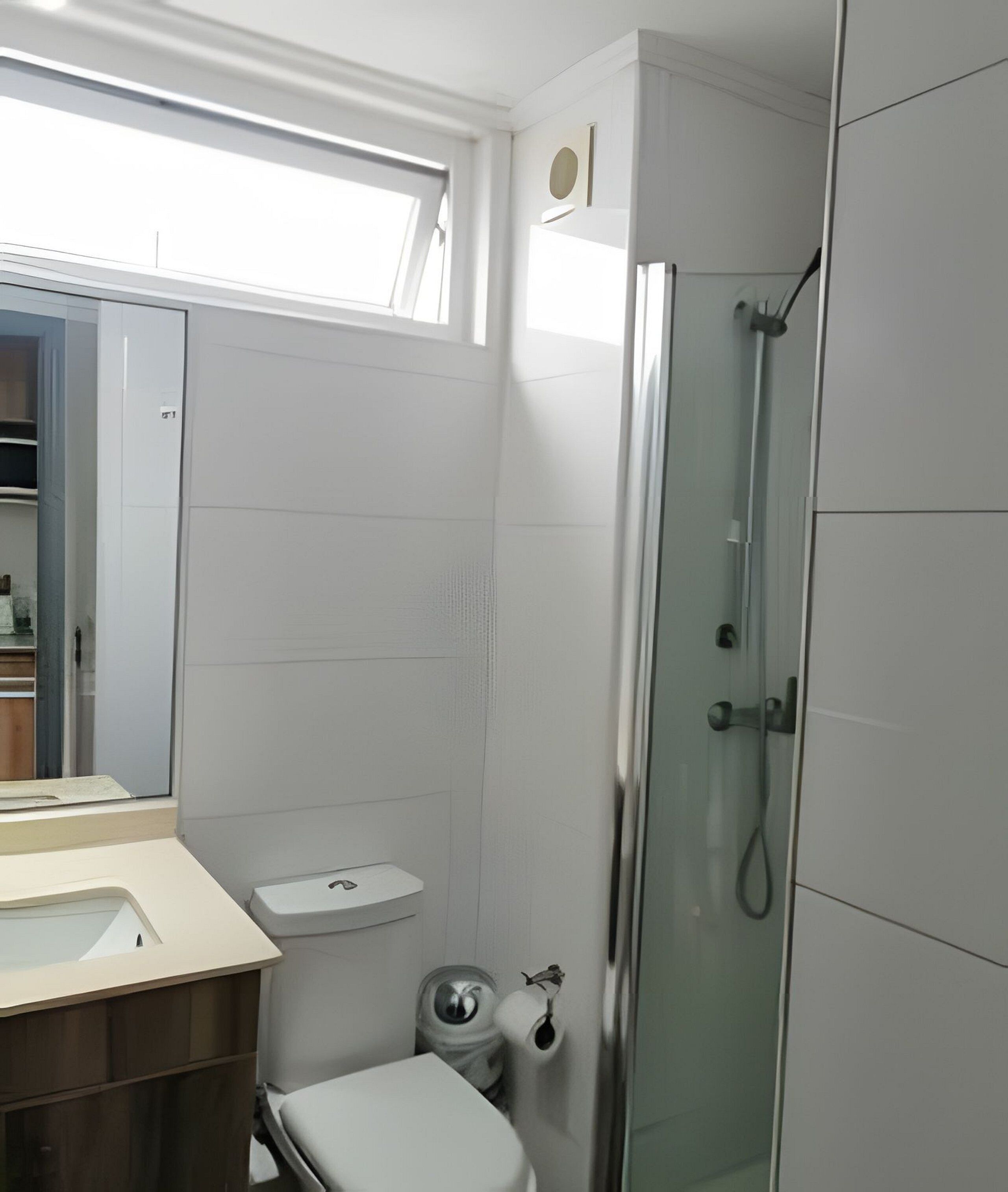 Une salle de bain moderne avec une douche à l’italienne, des toilettes et un lavabo.