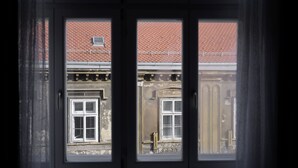 A view through a window with a brick building and a balcony. - Deluxe Apartments Ria (Zagreb)