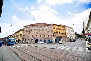 Une station de tramway avec un tram, un passage piéton et un bâtiment sur lequel est apposée une enseigne indiquant « Change ».