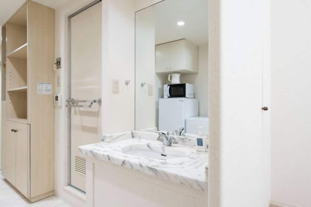 Une salle de bain avec un lavabo, un miroir et des placards.