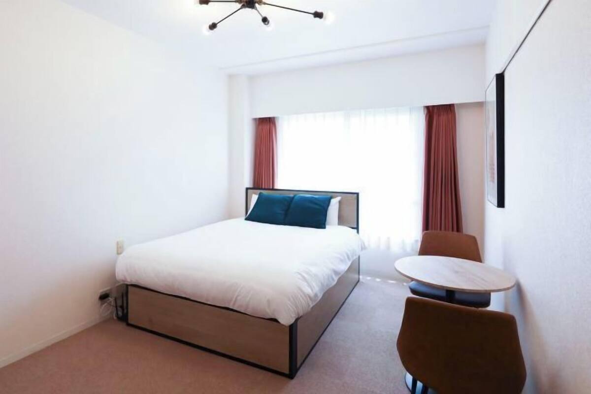 Une chambre d’hôtel avec un lit, une table et une chaise.