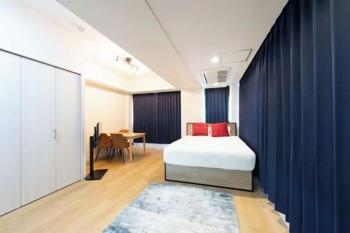 Une chambre d’hôtel moderne, équipée d’un lit, d’un bureau et d’une chaise.