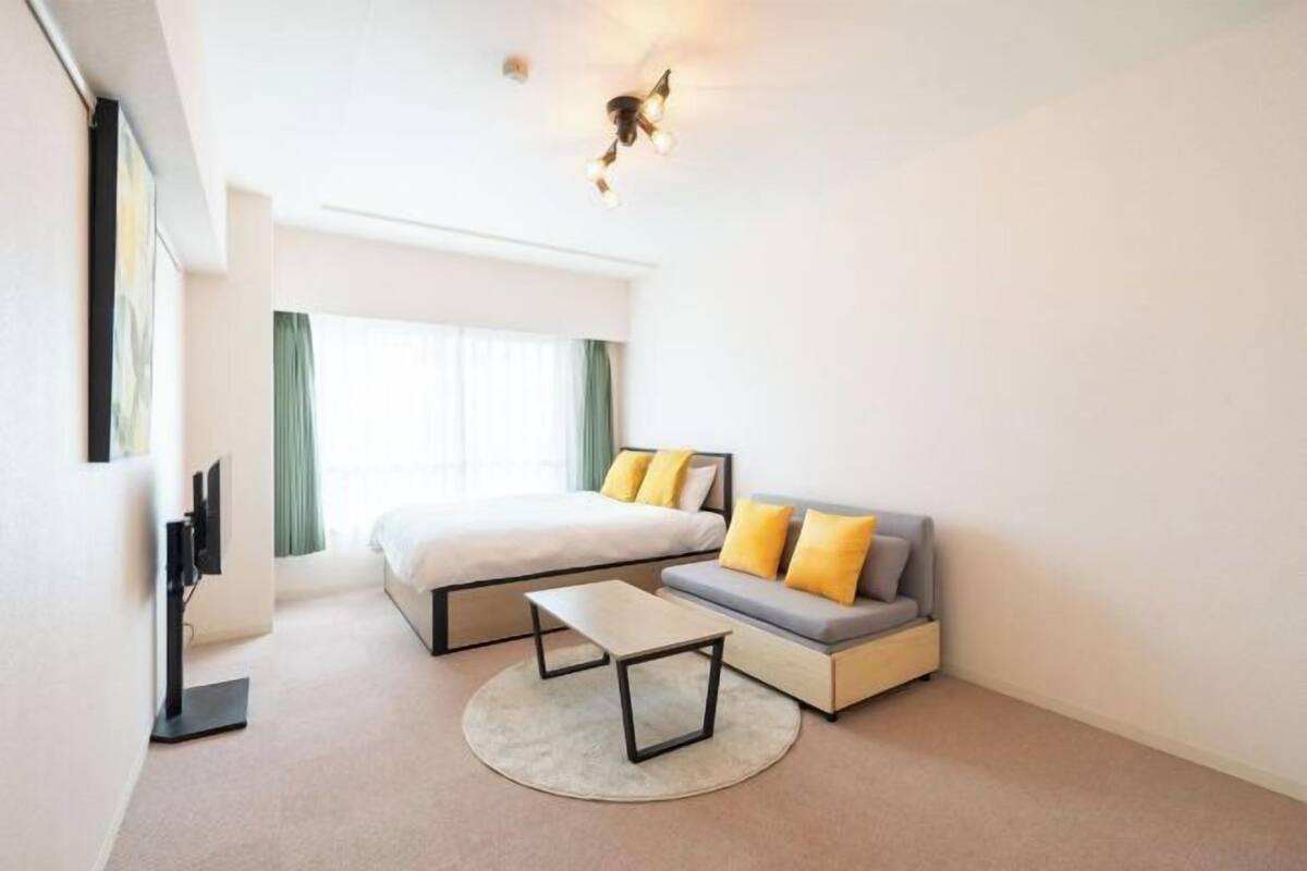 Une chambre d’hôtel moderne équipée d’un lit, d’un canapé et d’un téléviseur à écran plat.