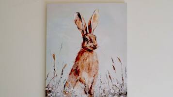 Uma pintura de um coelho em um campo.
