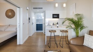 Un interior moderno con cocina, comedor y sala de estar con sofá y planta.