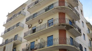 A multi-story building with balconies, air conditioning units, and a stone facade. - La Regina del Sole (Reggio Calabria)