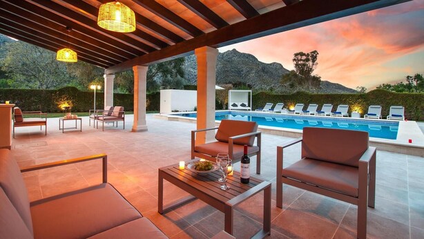 An outdoor patio with a pool, lounge chairs, and a table with a bottle and glasses. - H2947 Finca Papa near Pollenca for 12 persons near Pollenca (Pollenca)