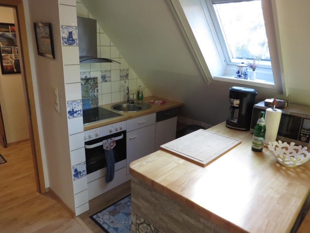 Eine Küche mit Holzausziehtisch, Spüle, Herd und Fenster mit Blick.
