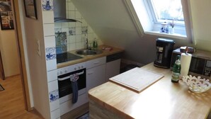 A kitchen with a wooden countertop, a sink, a stove, and a window with a view. - NEW! Vacation apartment Sonnenschein OG (Neuschoo)
