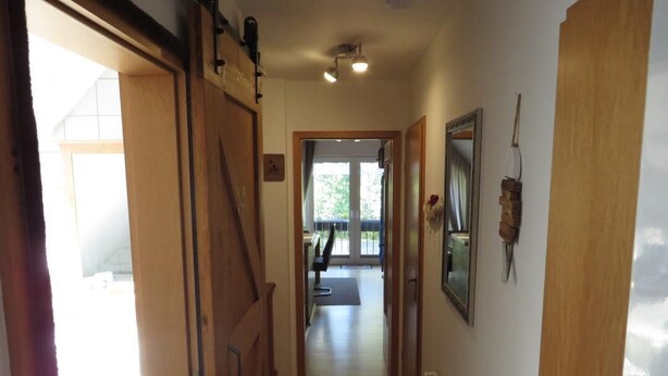 A hallway with wooden doors, a radiator, and a patterned rug. - NEW! Vacation apartment Sonnenschein OG (Neuschoo)