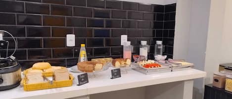 A buffet counter with various food items and condiments.