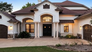 A two-story house with a central entrance, a covered porch, and a driveway.
