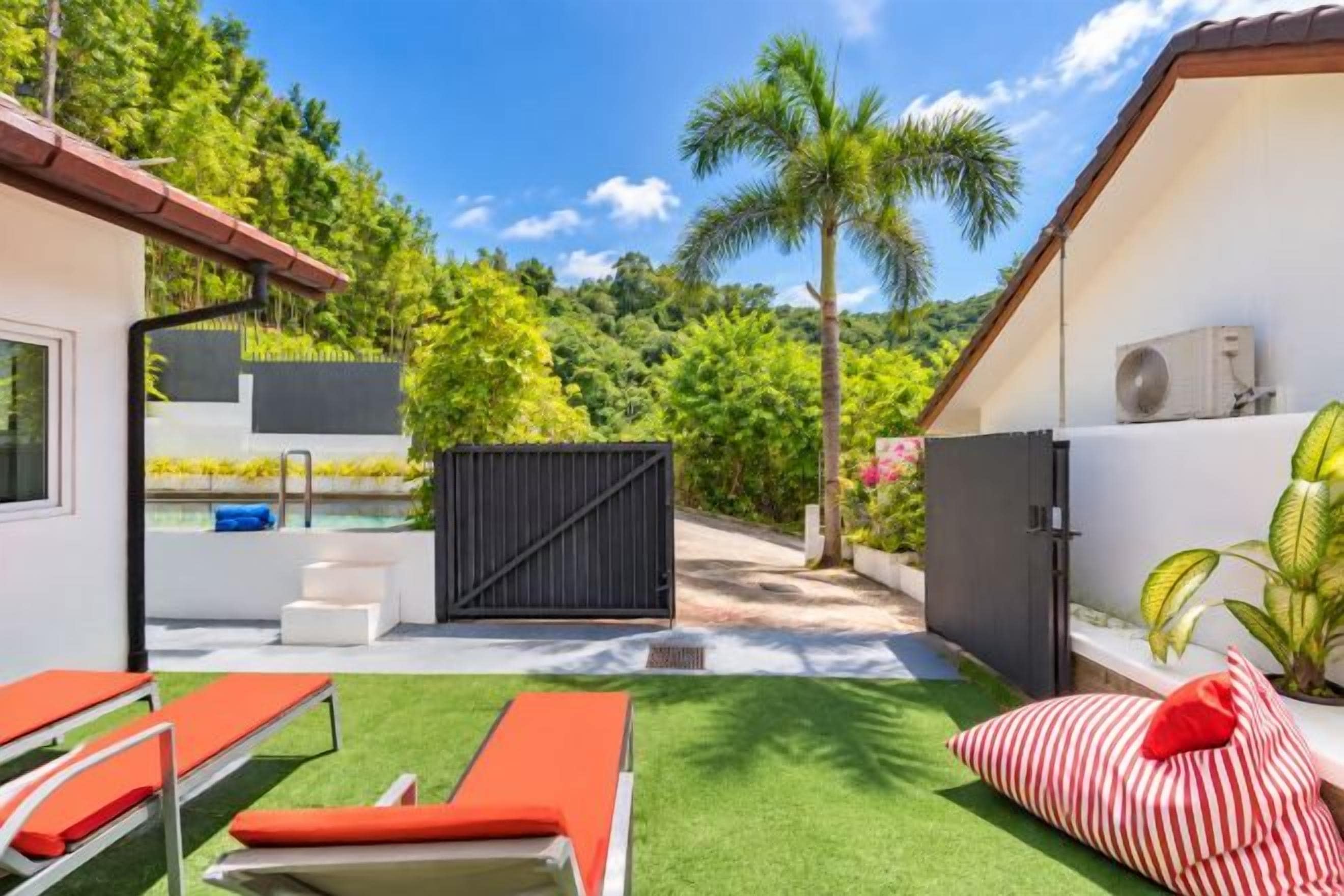 Ein Garten mit Pool, Liegestühlen und einer überdachten Terrasse.