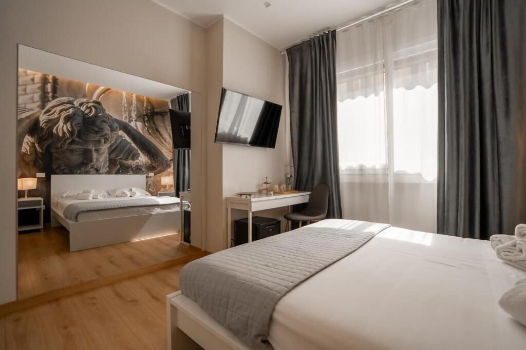 Una habitación de hotel moderna con cama, escritorio y televisor.