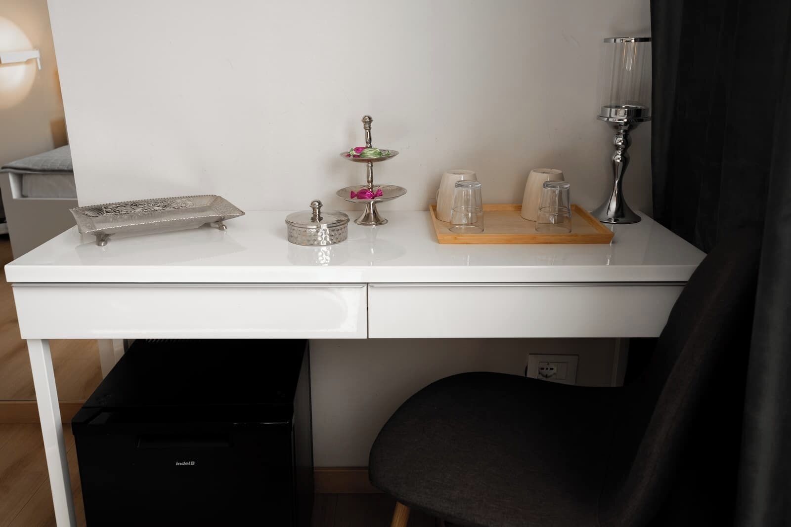 A white desk with a tray, a small decorative item, and a lamp.