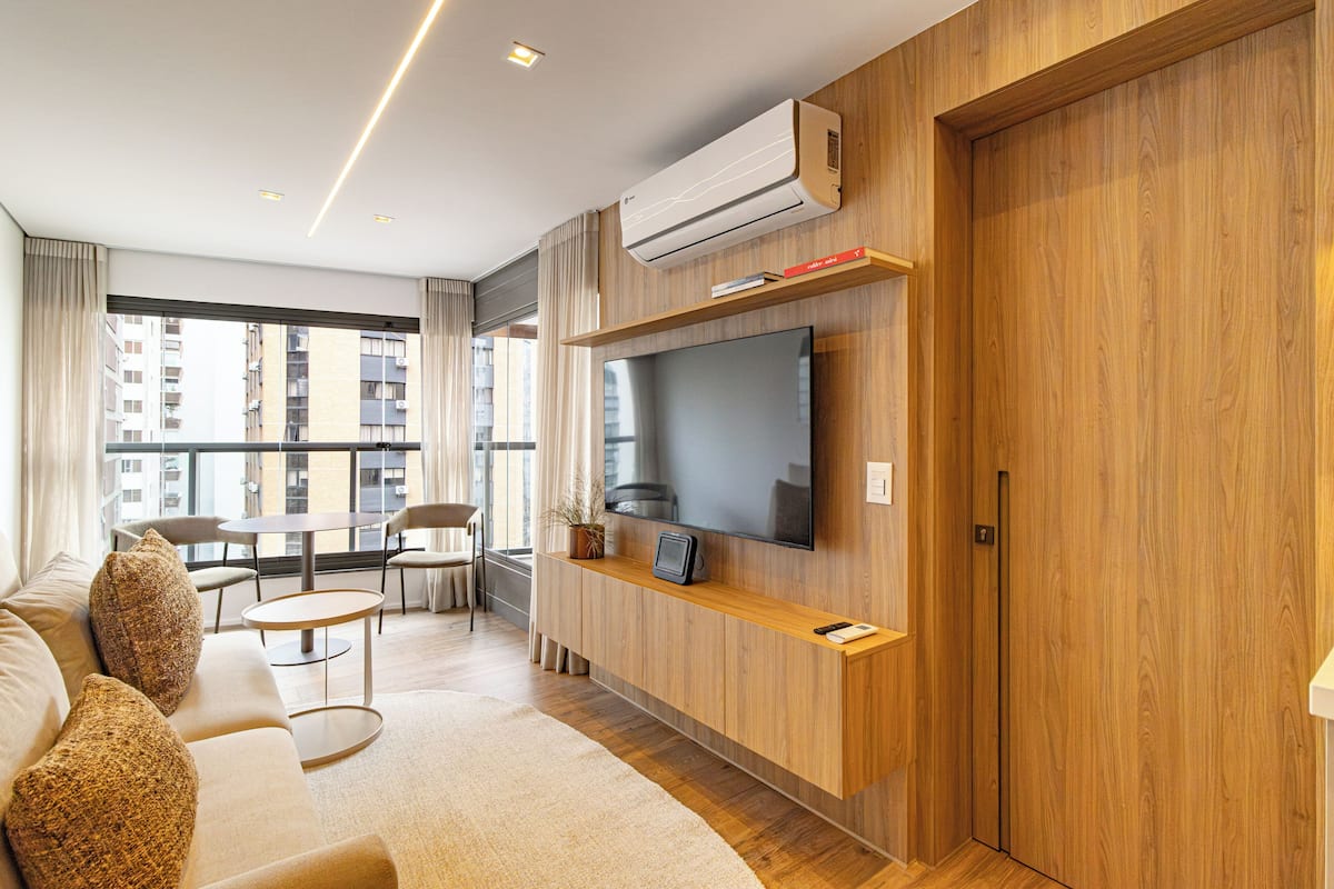Una sala moderna con sofá, televisor y comedor.