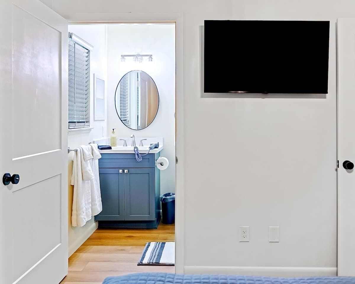 A room with a bathroom featuring a sink, mirror, and towel rack.
