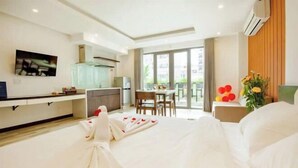 Une chambre d’hôtel comprenant un lit, un coin repas et une cuisine.