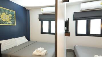 Una habitación de hotel con dos camas, un cuadro en la pared y un equipo de aire acondicionado.