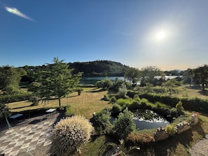 A landscaped garden with a pond, trees, and a view of a lake. - Hotel Sättele, Im Hegau, nahe Singen und Radolfzell am Bodensee (Steißlingen)