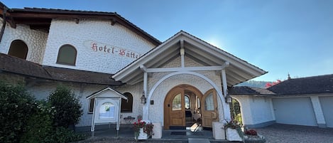 A traditional building with a sign reading "Hotel Säcker". It features a cobblestone courtyard and a wooden entrance with an arched doorway.
