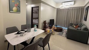 Ein modernes Wohnzimmer mit Essbereich, einer Couch, einer Bärenstatue und einem Wandbild.