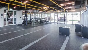 A gym with weightlifting equipment, benches, and a mirrored wall. - Dubai Hills Sleeps 4 With Awesome Swimming Pool (Dubai)