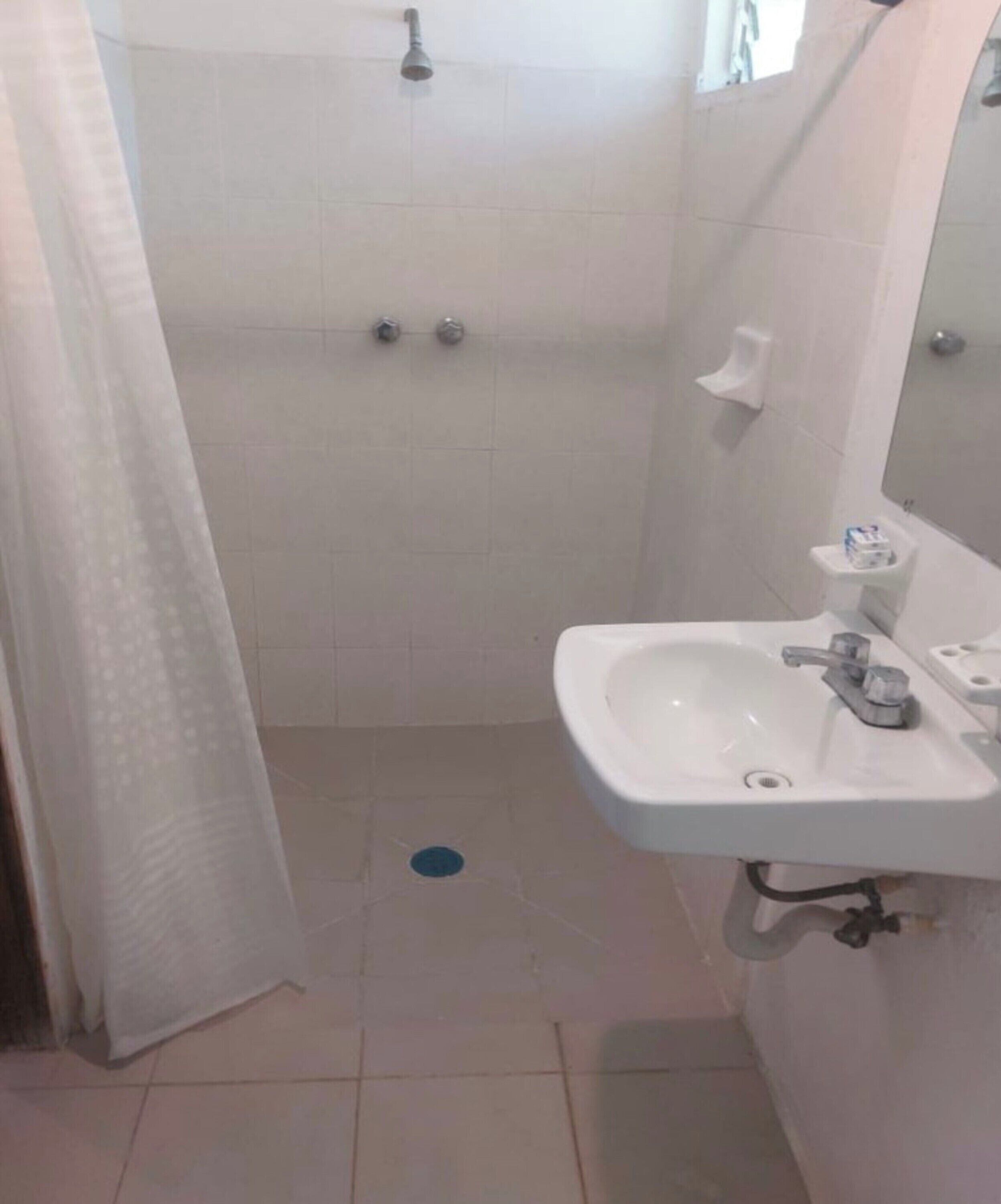 Un baño con ducha, lavabo e inodoro.
