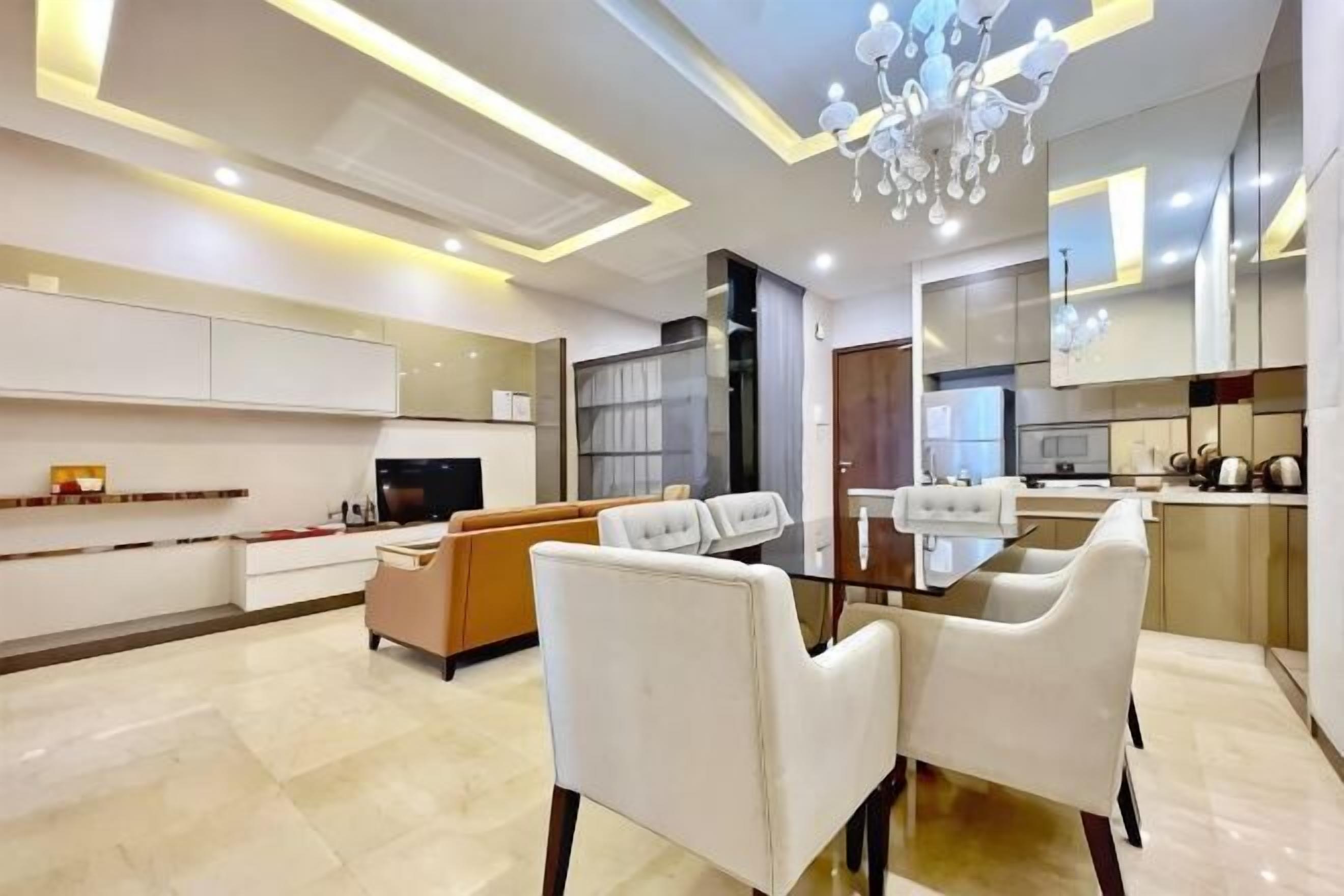 A modern living room with a dining area, a kitchen, and a TV.